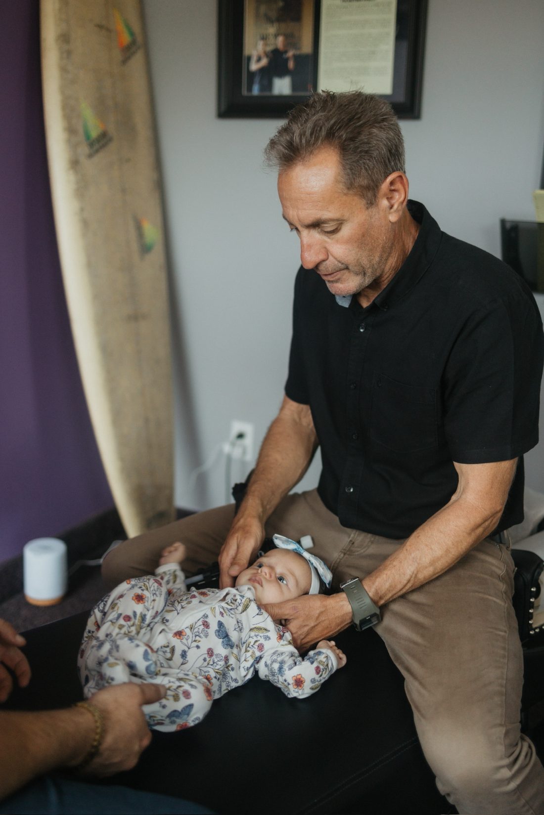 Dr. Billy DeMoss giving a newborn a gentle fingertip adjustment